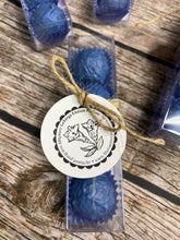Lade das Bild in den Galerie-Viewer, Enzian Praline ein Trüffel gefüllt mit Orginal Turra Gebirgs Enzian und Nougat ummantelt von Vollmichschokolade in Blau eingefärbt in einer Klarsichtschachtel mit Schleife und liebevollem Etikett verpackt.
