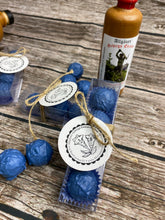 Lade das Bild in den Galerie-Viewer, Enzian Praline ein Trüffel gefüllt mit Orginal Turra Gebirgs Enzian und Nougat ummantelt von Vollmichschokolade in Blau eingefärbt in einer Klarsichtschachtel mit Schleife und liebevollem Etikett verpackt.
